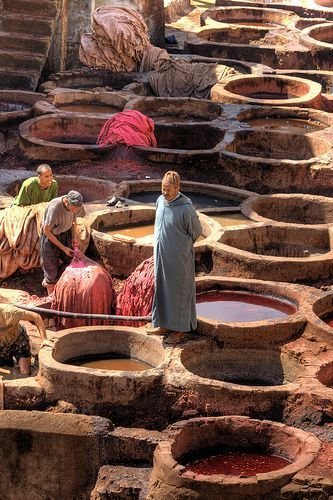 Leather rests in vats filled with colourful dyes…